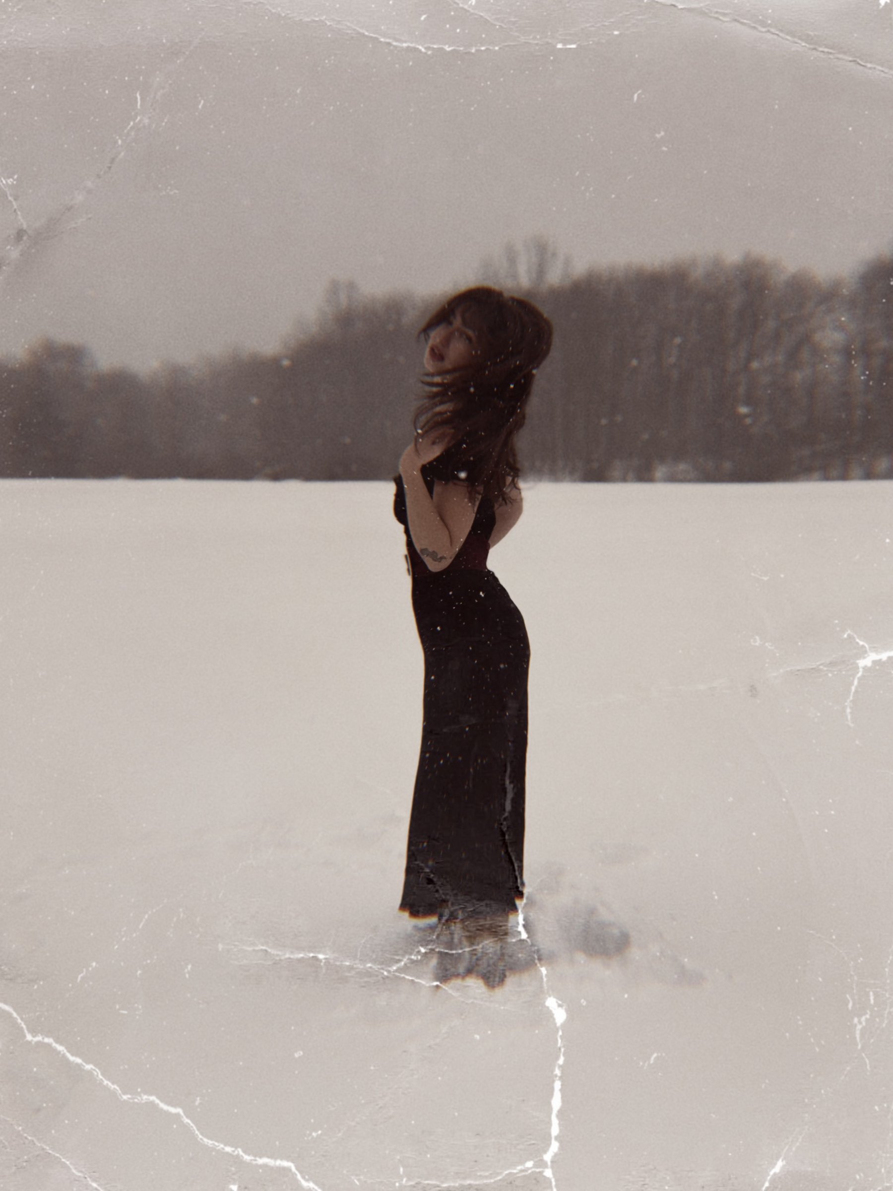 Abigail Royce standing in a snow field in a black dress